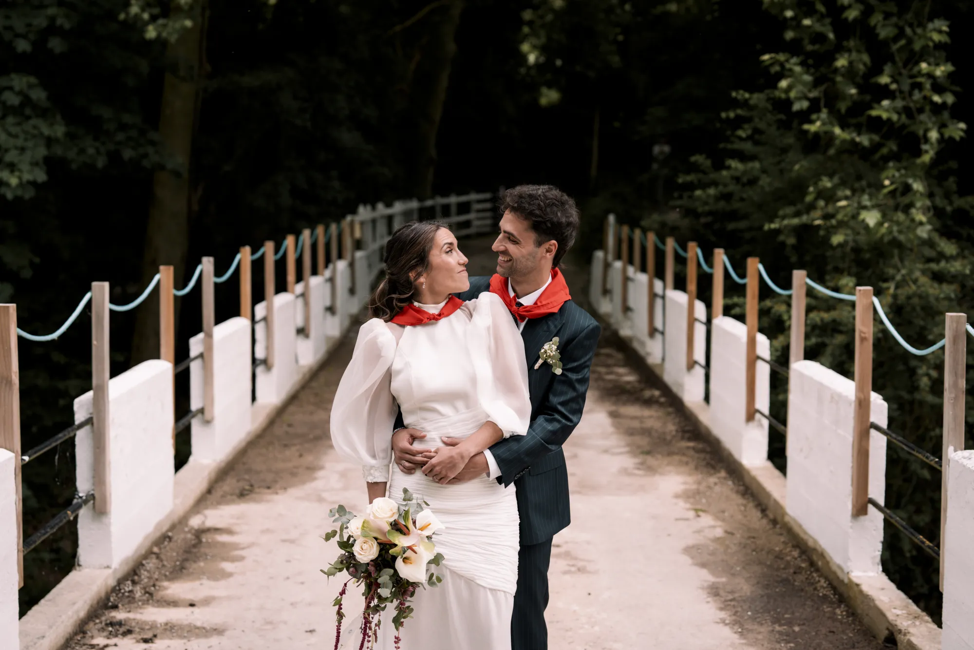 Los novios se abrazan en un puente de madera